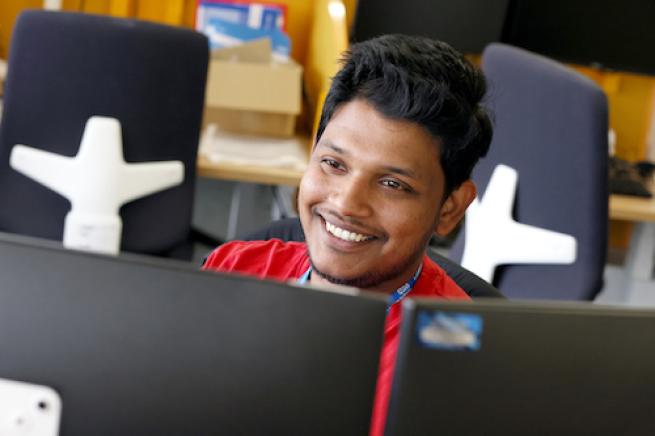 Man sits at desk with two computer screens in front of him