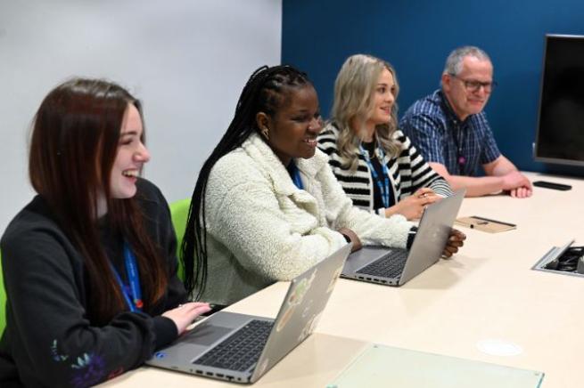 Four people sitting at a desk