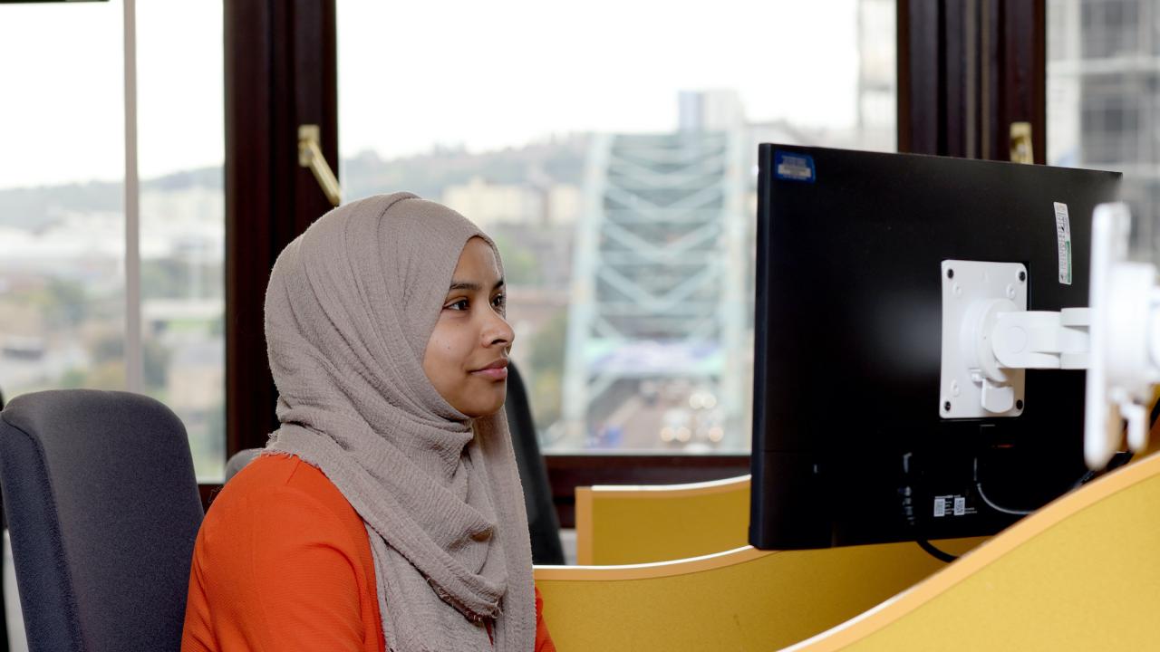 Woman sits at computer in an office 