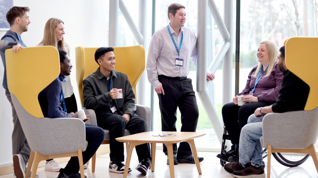 Colleagues sat having a conversation in a communal area of the office.
